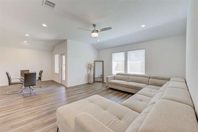 living room featuring vaulted ceiling, plenty of natural light, ceiling fan, and light wood-type flooring