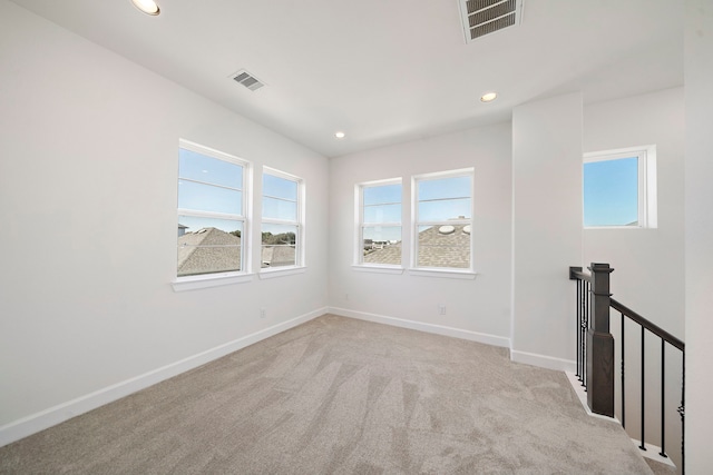 unfurnished room featuring light carpet