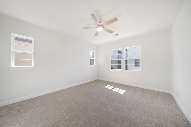 carpeted spare room featuring ceiling fan