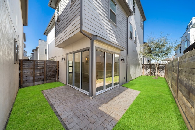 rear view of house featuring a patio and a lawn