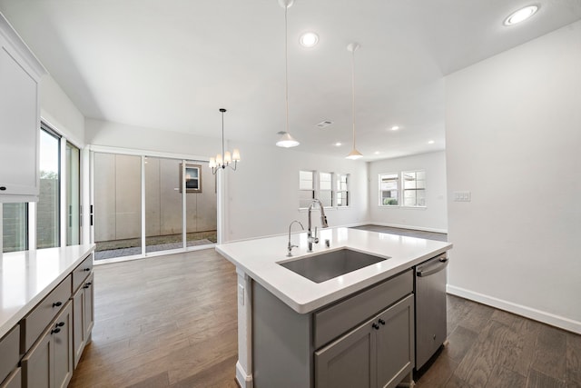 kitchen with sink, a center island with sink, dishwasher, gray cabinets, and pendant lighting