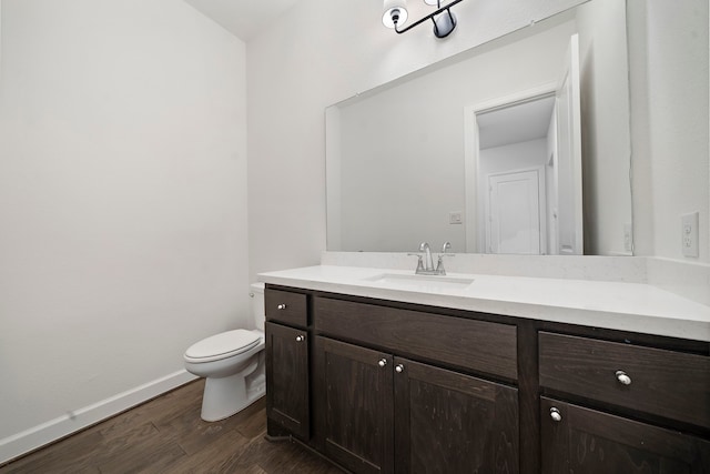 bathroom with vanity, toilet, and hardwood / wood-style floors