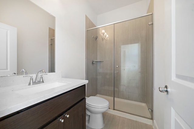 bathroom featuring an enclosed shower, vanity, hardwood / wood-style floors, and toilet