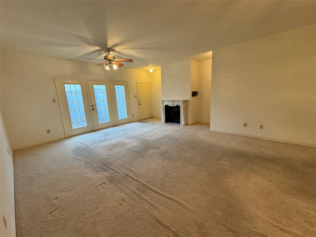 unfurnished living room with carpet floors, a premium fireplace, and ceiling fan