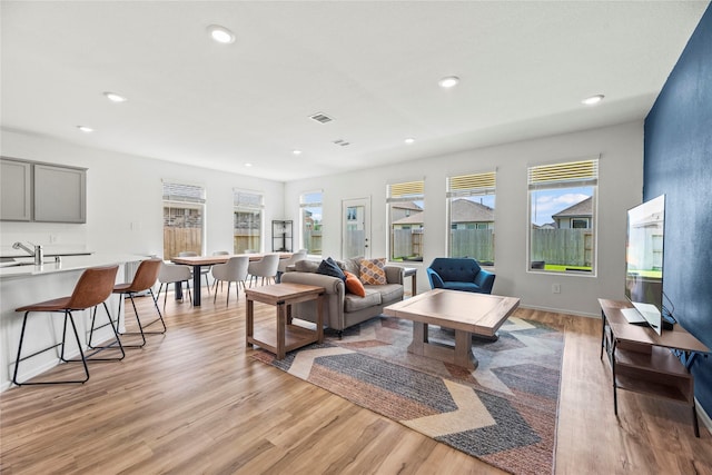 living room with sink and light hardwood / wood-style flooring