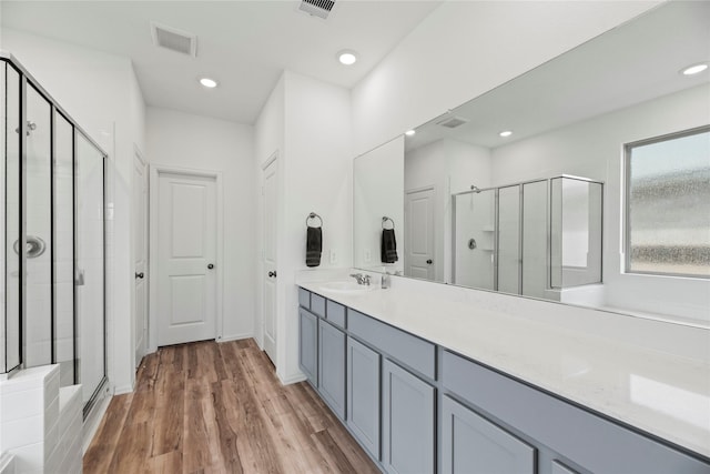 bathroom featuring vanity, hardwood / wood-style flooring, and a shower with shower door