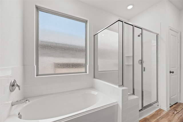 bathroom with hardwood / wood-style flooring, a healthy amount of sunlight, and shower with separate bathtub