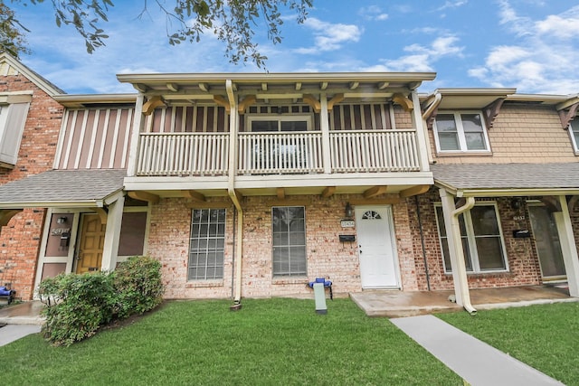 townhome / multi-family property with a balcony and a front yard