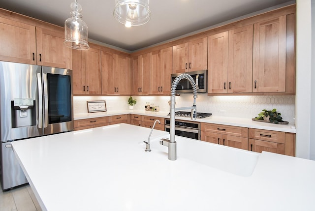 kitchen with tasteful backsplash, hanging light fixtures, and stainless steel appliances