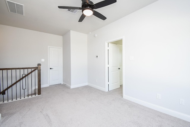 carpeted spare room with ceiling fan