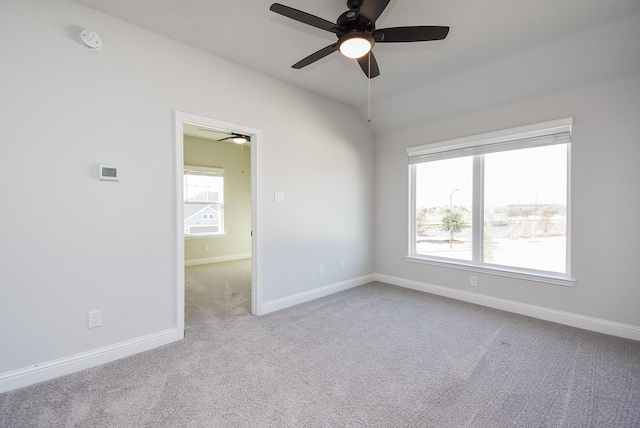 unfurnished room featuring lofted ceiling and light carpet