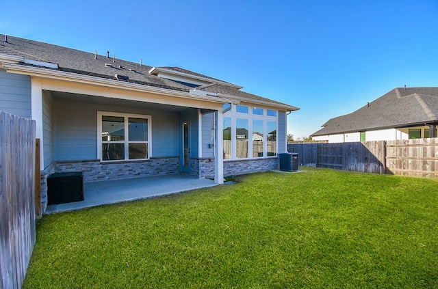 back of property featuring a lawn, central AC unit, and a patio area