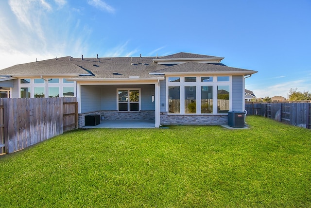 rear view of property with central AC unit, a patio area, and a lawn