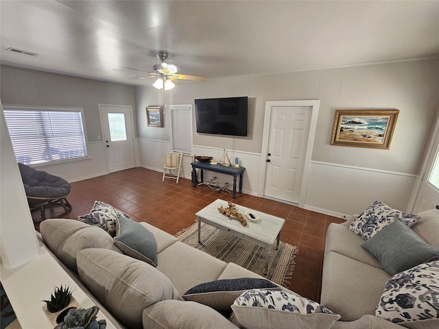 living room with dark tile patterned floors and ceiling fan