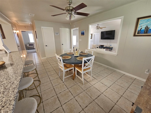 tiled dining room featuring ceiling fan and ornamental molding