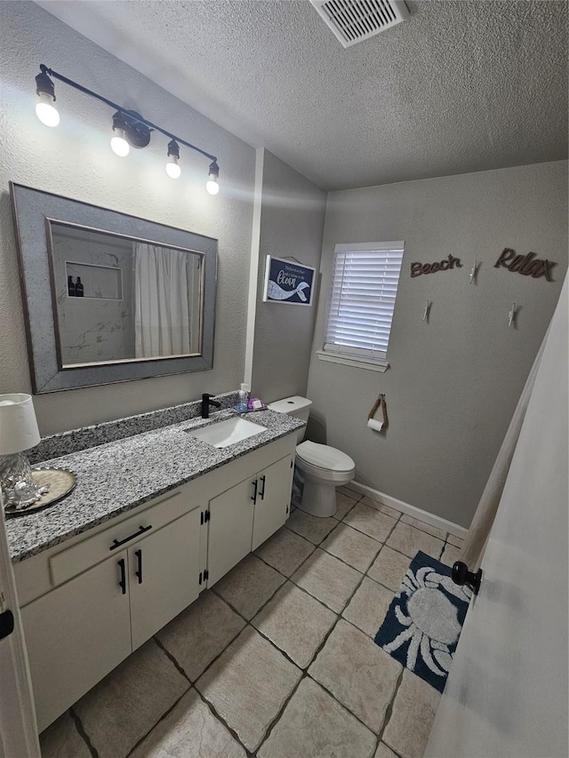 bathroom featuring vanity, tile patterned floors, toilet, and a textured ceiling