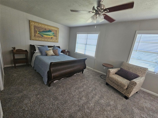 bedroom featuring ceiling fan, a textured ceiling, and dark colored carpet