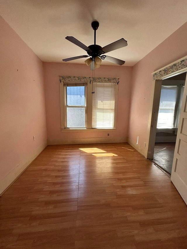 empty room with ceiling fan and wood-type flooring