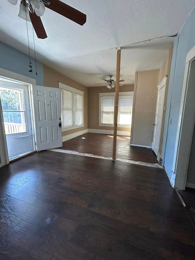 entrance foyer with dark wood-type flooring, ceiling fan, lofted ceiling, and a textured ceiling