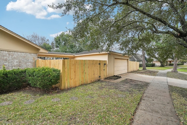 view of home's exterior with a garage and a lawn