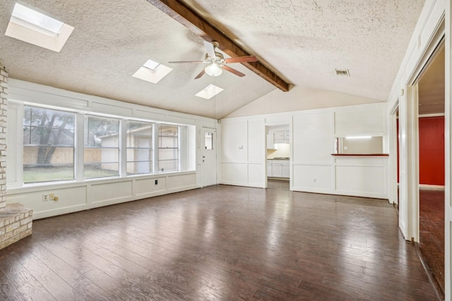 unfurnished living room with ceiling fan, dark hardwood / wood-style flooring, a textured ceiling, and lofted ceiling with skylight