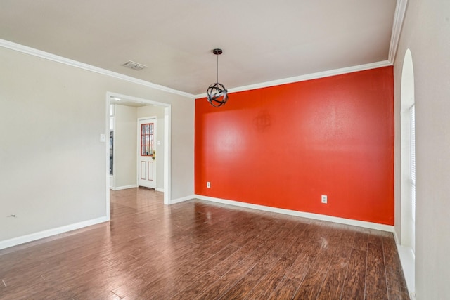 spare room featuring ornamental molding, hardwood / wood-style floors, and a chandelier