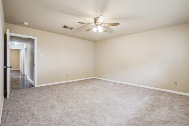 spare room featuring dark carpet and ceiling fan