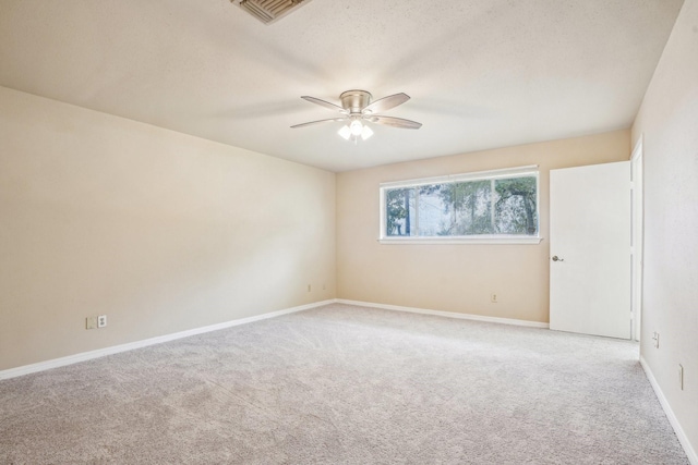 carpeted empty room with ceiling fan and a textured ceiling