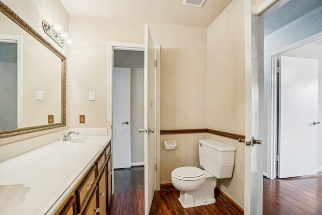 bathroom with vanity, hardwood / wood-style floors, and toilet