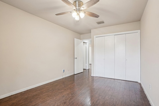 unfurnished bedroom with ceiling fan, dark hardwood / wood-style flooring, and a closet