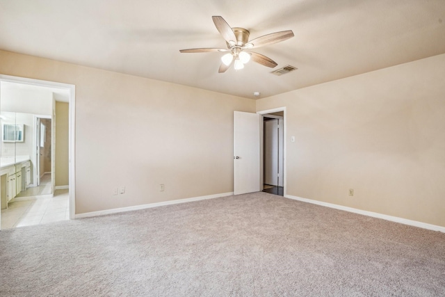 spare room featuring light carpet and ceiling fan