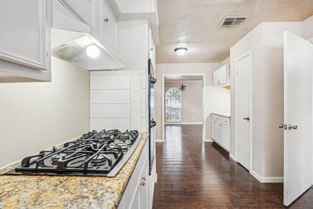 kitchen featuring dark wood-type flooring, gas cooktop, light stone countertops, a textured ceiling, and white cabinets