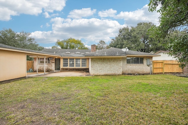 back of house with a lawn and a patio area