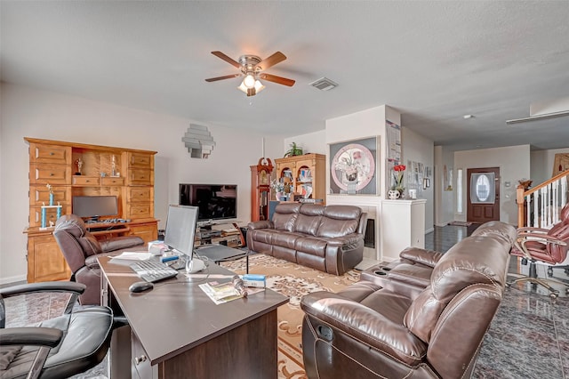 living room featuring a textured ceiling and ceiling fan