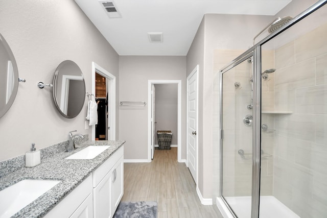 bathroom with vanity, wood-type flooring, and an enclosed shower