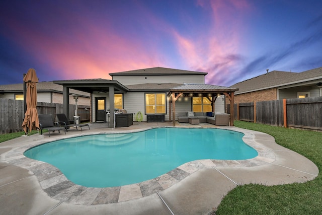 pool at dusk with a gazebo, an outdoor hangout area, and a patio