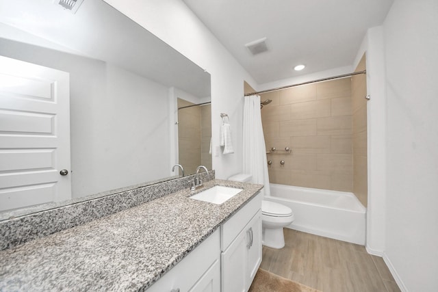 full bathroom with hardwood / wood-style flooring, vanity, shower / bath combo, and toilet