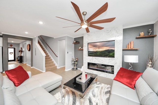 living room with ornamental molding, light wood-type flooring, and a fireplace