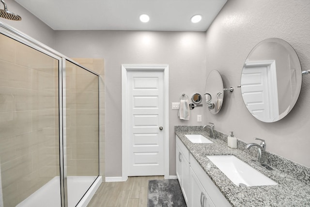 bathroom with vanity, a shower with door, and hardwood / wood-style floors