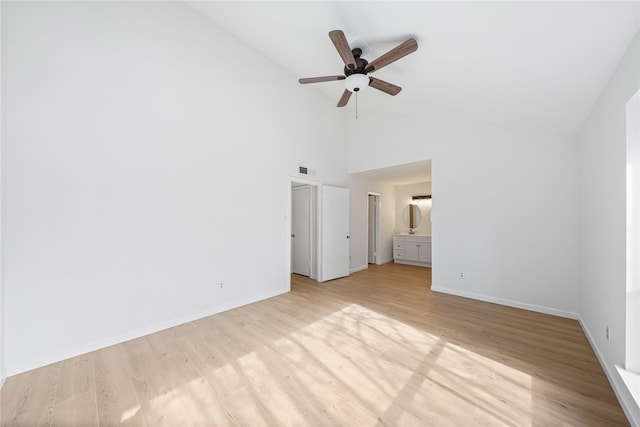 interior space with ensuite bathroom, ceiling fan, high vaulted ceiling, and light hardwood / wood-style flooring