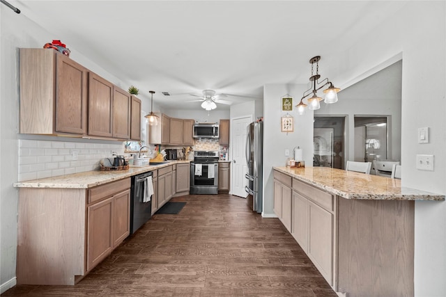 kitchen featuring stainless steel appliances, decorative light fixtures, light stone counters, and kitchen peninsula