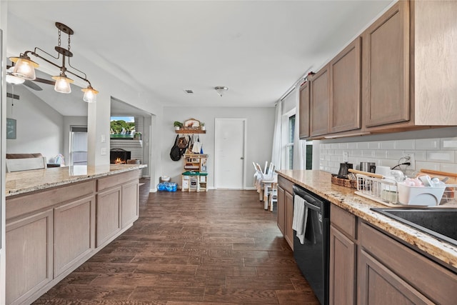 kitchen featuring light stone counters, dark hardwood / wood-style flooring, dishwashing machine, pendant lighting, and decorative backsplash