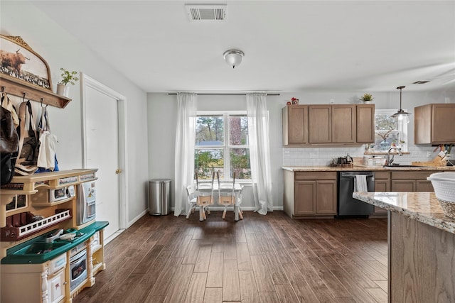 kitchen featuring light stone counters, decorative light fixtures, dark hardwood / wood-style floors, and dishwasher