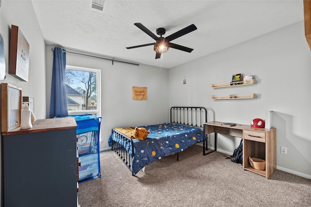 bedroom featuring ceiling fan, a textured ceiling, and carpet