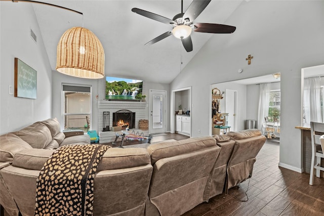 living room with a fireplace, high vaulted ceiling, dark hardwood / wood-style floors, and ceiling fan