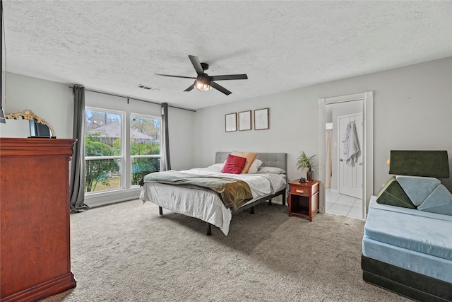 carpeted bedroom featuring a textured ceiling and ceiling fan