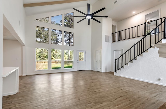 unfurnished living room with ceiling fan, dark hardwood / wood-style flooring, and high vaulted ceiling