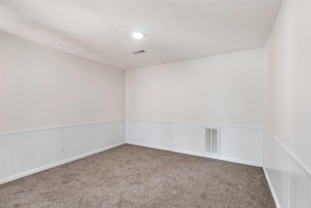 carpeted spare room featuring a textured ceiling