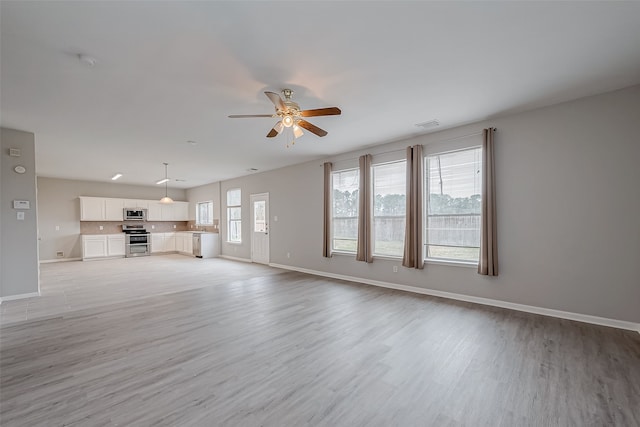 unfurnished living room with light wood-type flooring and ceiling fan