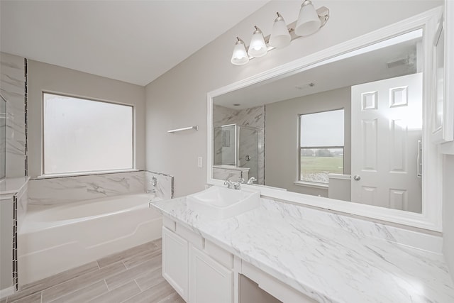 bathroom featuring vanity and shower with separate bathtub